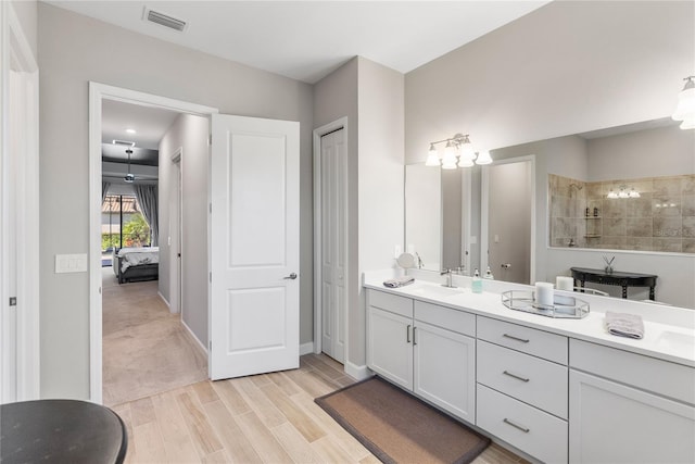 bathroom featuring a walk in shower, connected bathroom, wood finished floors, vanity, and visible vents