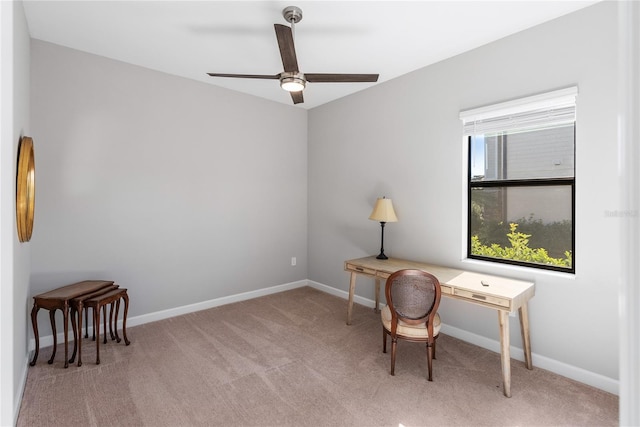 office space with light carpet, baseboards, and a ceiling fan