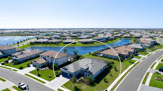 drone / aerial view featuring a residential view and a water view