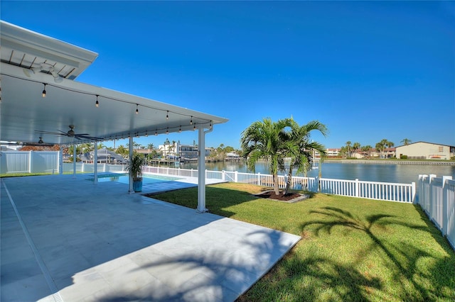 view of yard featuring a water view, ceiling fan, and a patio area