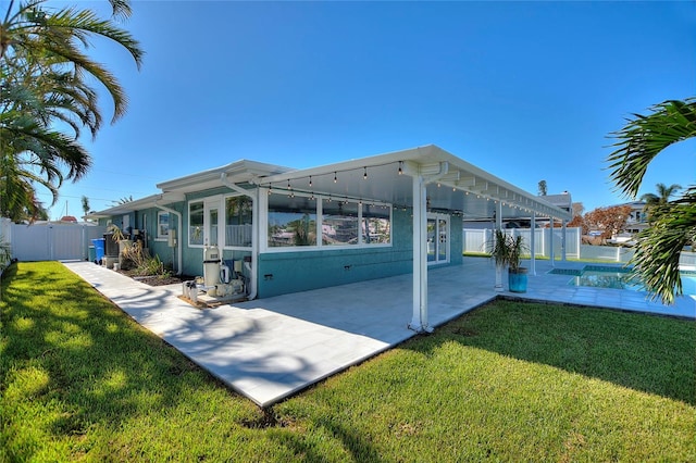 rear view of property featuring a lawn and a patio area