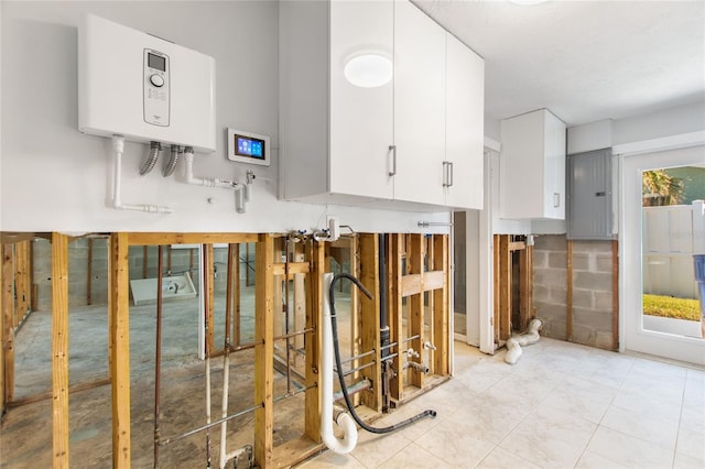 interior space with water heater and white cabinets