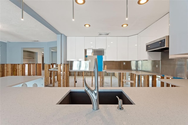 kitchen with white cabinetry and sink