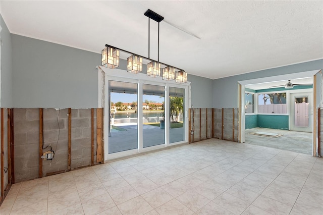 unfurnished room with light tile patterned floors, a textured ceiling, tile walls, and ceiling fan