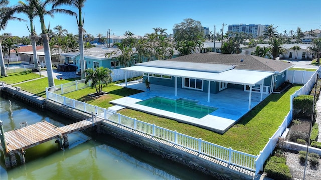 back of property with a lawn, a water view, a fenced in pool, and a patio