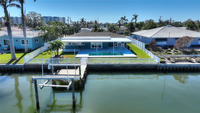 rear view of house featuring a lawn, a water view, and a patio