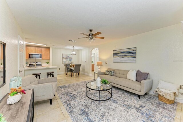 tiled living room featuring ceiling fan and a textured ceiling