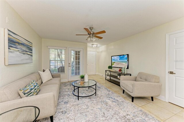 living room with ceiling fan and light tile patterned flooring