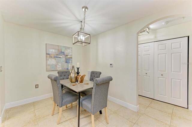 dining area with a notable chandelier and light tile patterned floors