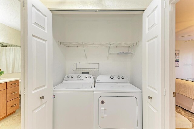 clothes washing area featuring independent washer and dryer and light tile patterned flooring