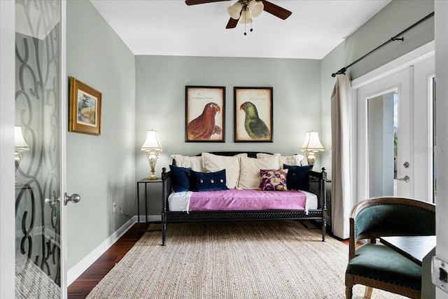 bedroom featuring ceiling fan, stacked washer / dryer, and hardwood / wood-style flooring