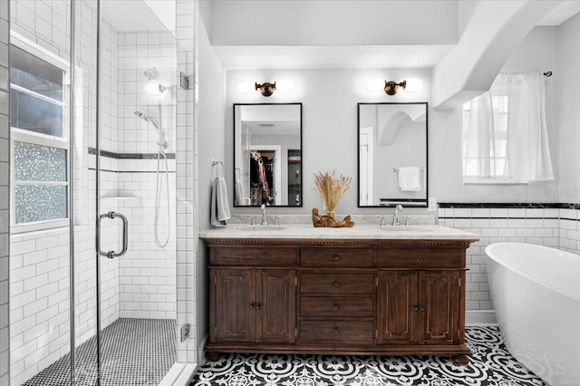 bathroom with a wealth of natural light, tile patterned floors, vanity, and plus walk in shower