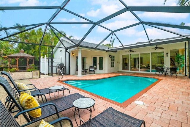 view of pool featuring ceiling fan, glass enclosure, a gazebo, french doors, and a patio