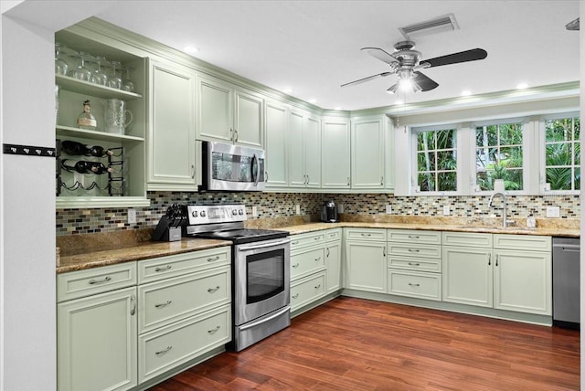 kitchen with stainless steel appliances, tasteful backsplash, dark wood-type flooring, light stone counters, and sink