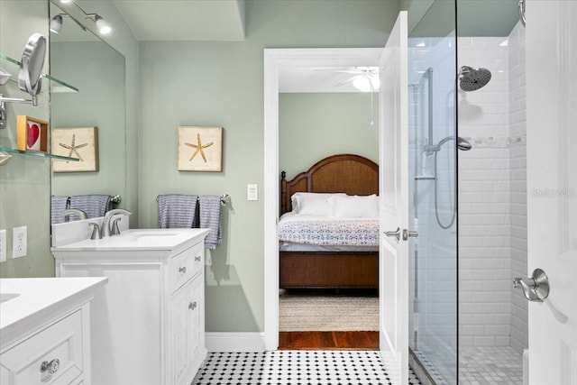 bathroom featuring ceiling fan, a tile shower, and vanity