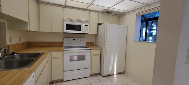 kitchen featuring a paneled ceiling, white appliances, sink, and cream cabinets