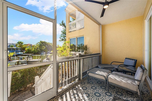 sunroom / solarium with a water view and ceiling fan