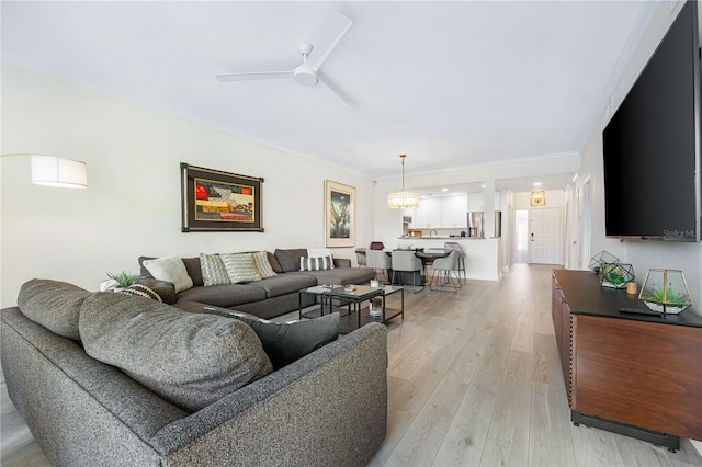 living room with ceiling fan, light wood-type flooring, and ornamental molding