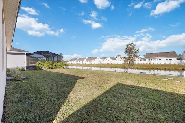 view of yard featuring a lanai and a water view