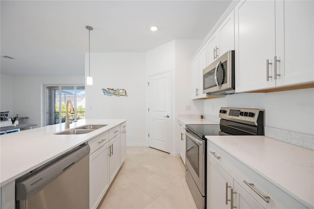 kitchen with white cabinets, sink, stainless steel appliances, and hanging light fixtures