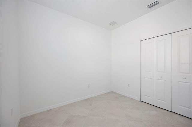 unfurnished bedroom with light tile patterned floors and a closet