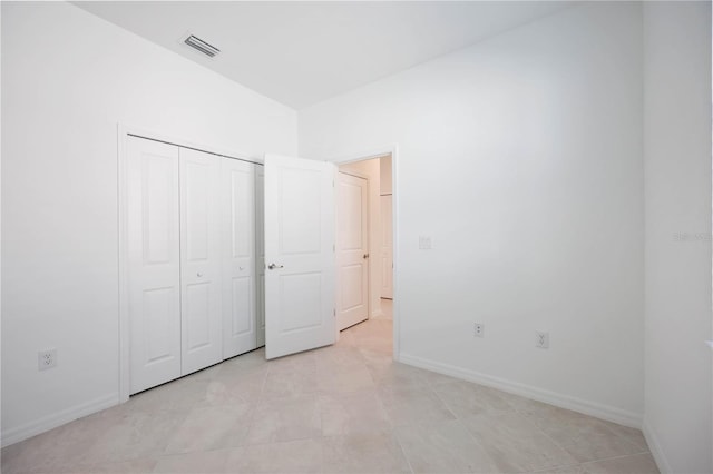 unfurnished bedroom featuring light tile patterned floors and a closet