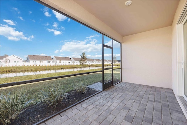 unfurnished sunroom featuring a water view