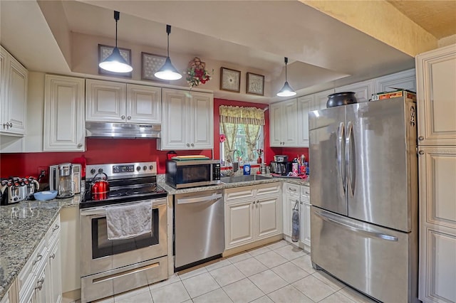 kitchen with light stone countertops, sink, decorative light fixtures, light tile patterned flooring, and appliances with stainless steel finishes