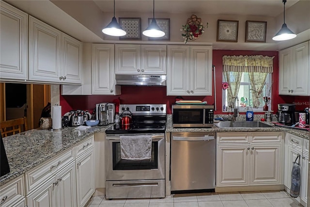 kitchen featuring sink, white cabinets, stainless steel appliances, and decorative light fixtures