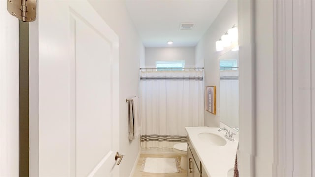 bathroom featuring curtained shower, vanity, and toilet