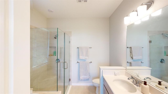 bathroom featuring vanity, toilet, and a shower with shower door