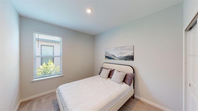 bedroom featuring light carpet and a closet