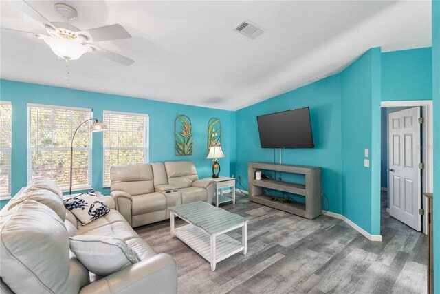 living room featuring ceiling fan, wood-type flooring, and vaulted ceiling