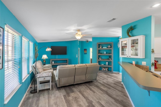 living room featuring ceiling fan, light hardwood / wood-style floors, and lofted ceiling