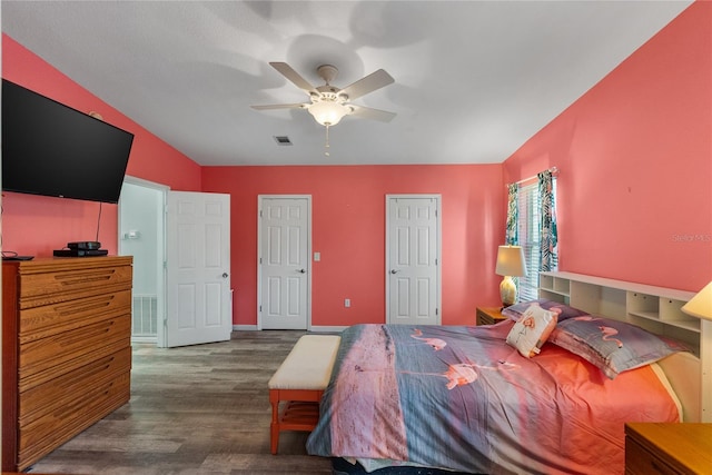 bedroom with dark hardwood / wood-style flooring, vaulted ceiling, and ceiling fan