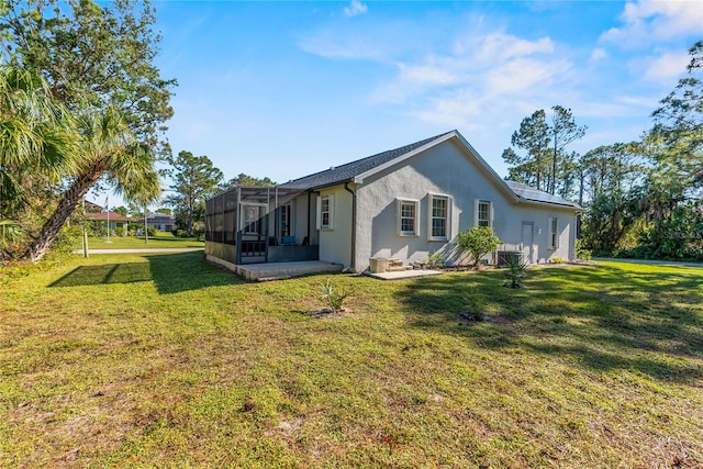 rear view of property featuring a lawn and glass enclosure