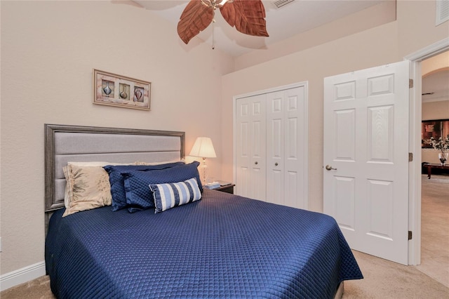 bedroom featuring a closet, light colored carpet, and ceiling fan