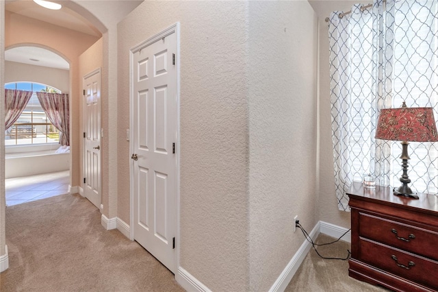 hall with light colored carpet