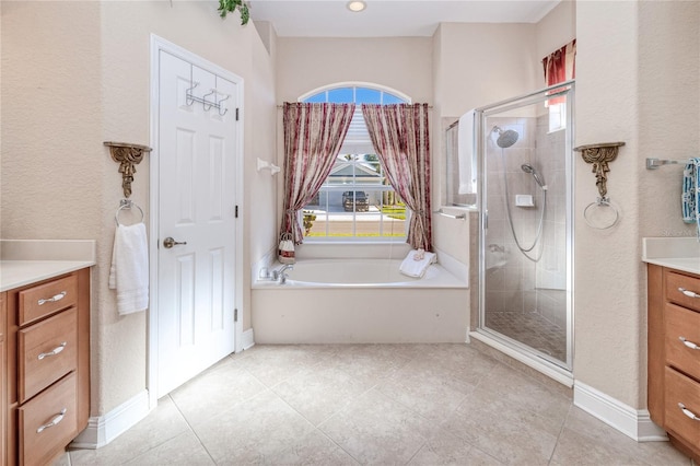 bathroom with tile patterned floors, vanity, and separate shower and tub