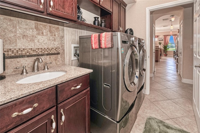 laundry room featuring separate washer and dryer, sink, and light tile patterned floors