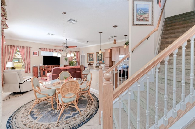 tiled dining area featuring ceiling fan and crown molding