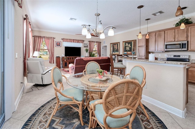 tiled dining room featuring a chandelier, a textured ceiling, ornamental molding, and sink