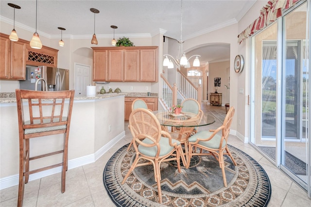 tiled dining room with ornamental molding and an inviting chandelier