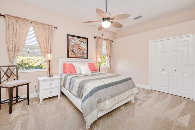 bedroom featuring ceiling fan, a closet, and light colored carpet