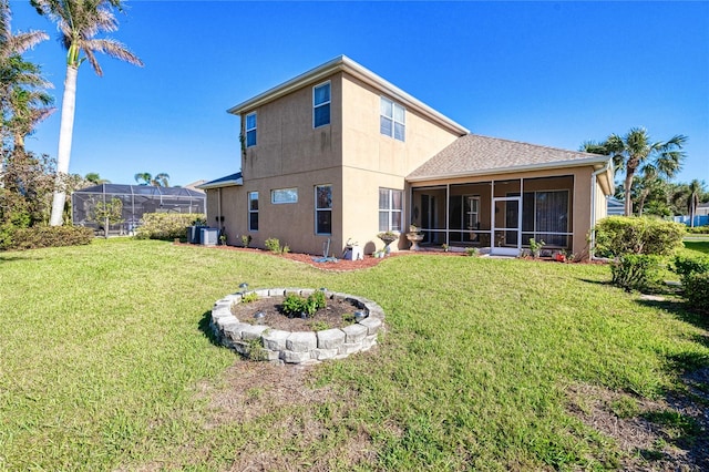 rear view of house featuring a sunroom and a yard