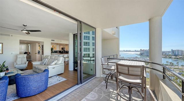 balcony featuring ceiling fan and a water view