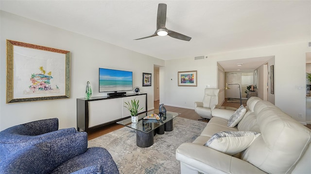 living room featuring ceiling fan and hardwood / wood-style floors