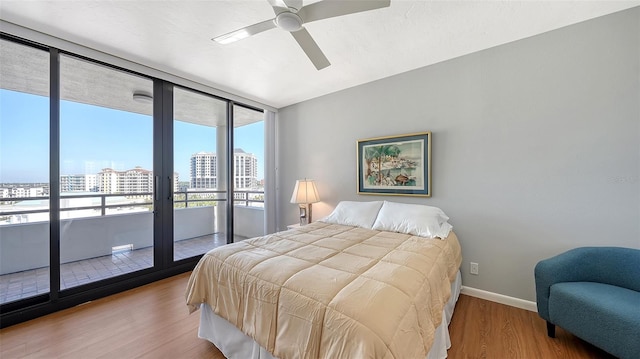 bedroom with wood-type flooring, access to outside, and ceiling fan