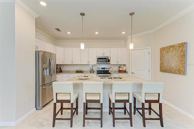 kitchen with light stone counters, stainless steel appliances, sink, a center island with sink, and white cabinets