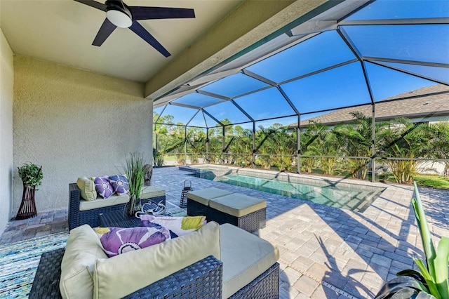 view of patio featuring glass enclosure, ceiling fan, and an outdoor living space